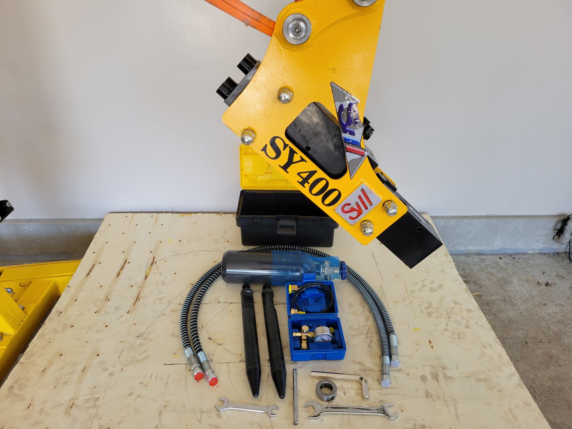 Hydraulic breaker hammer for excavators Canada and USA showing SY400 model with complete attachment kit including hoses chisels and tools for heavy duty demolition and construction work.

