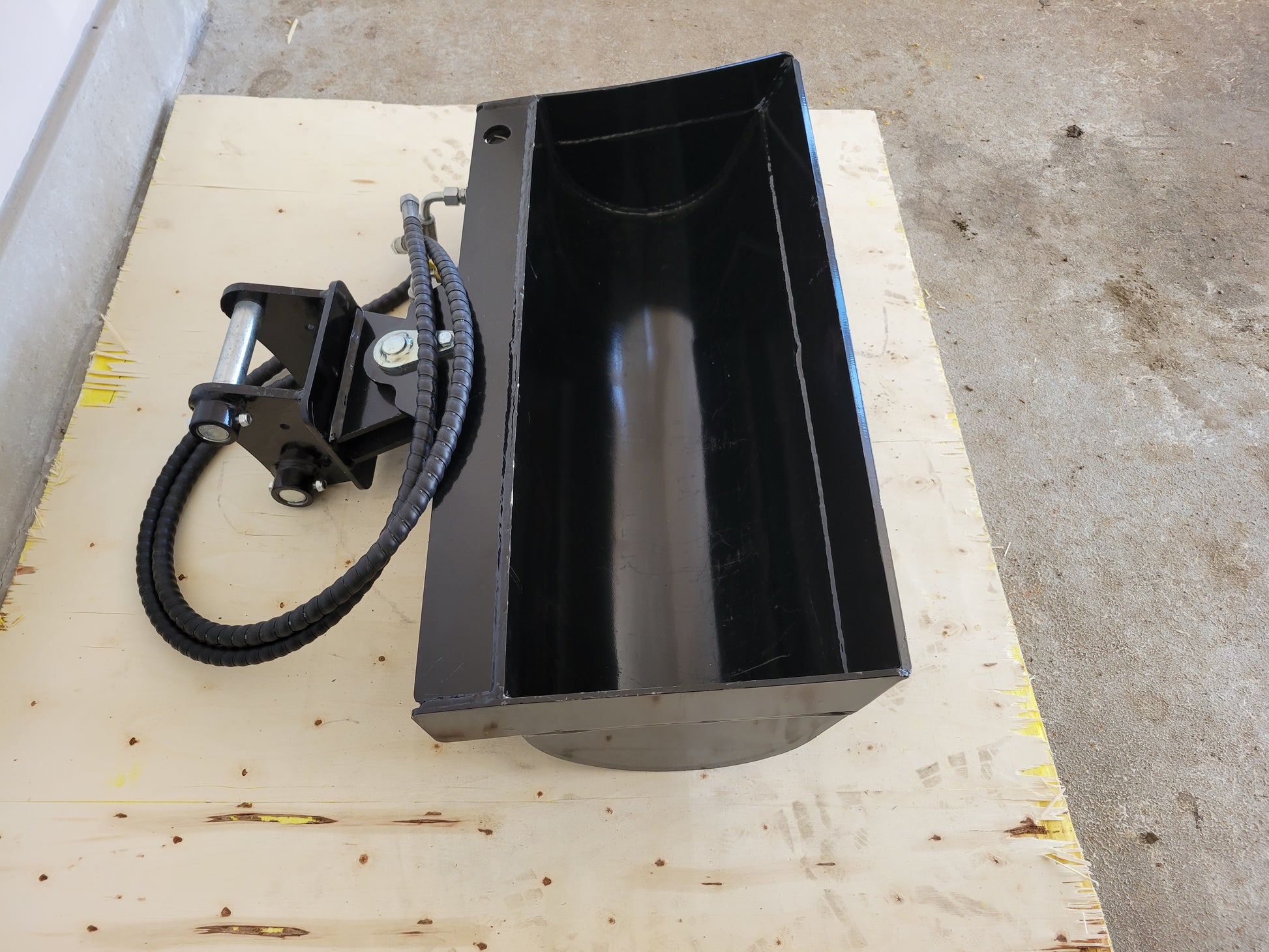 Hydraulic tilt bucket attachment top view showing hydraulic hose connection and deep design for mini excavator grading and digging in Canada