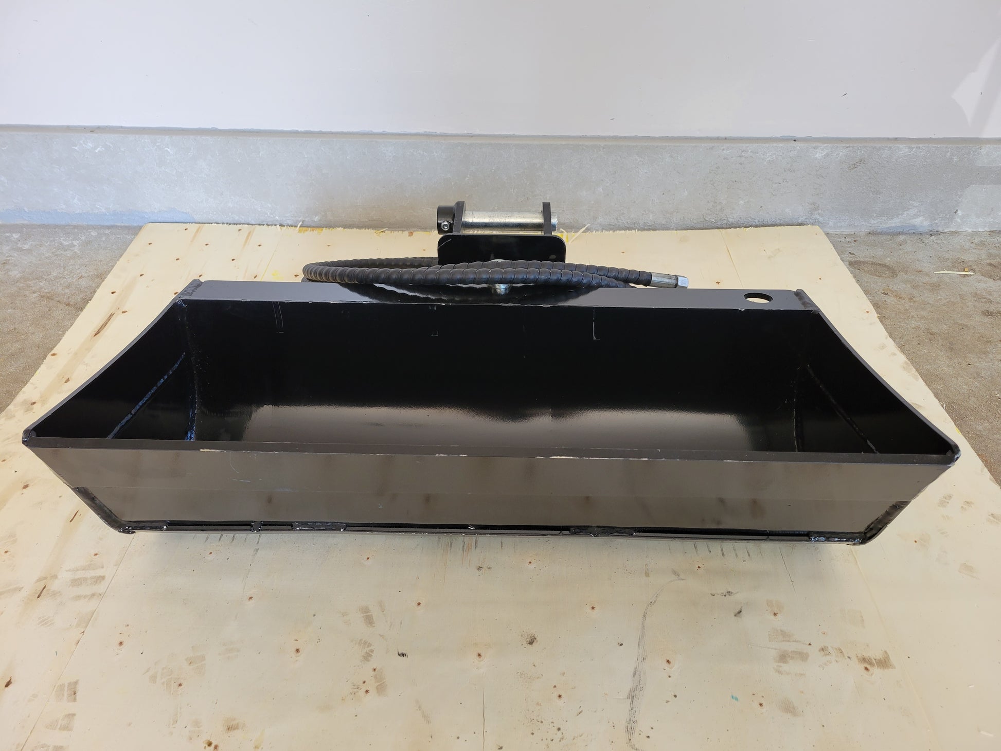 Hydraulic tilt bucket front view showing wide heavy duty design with hydraulic line mounted on excavator ideal for grading digging and construction work in Canada

