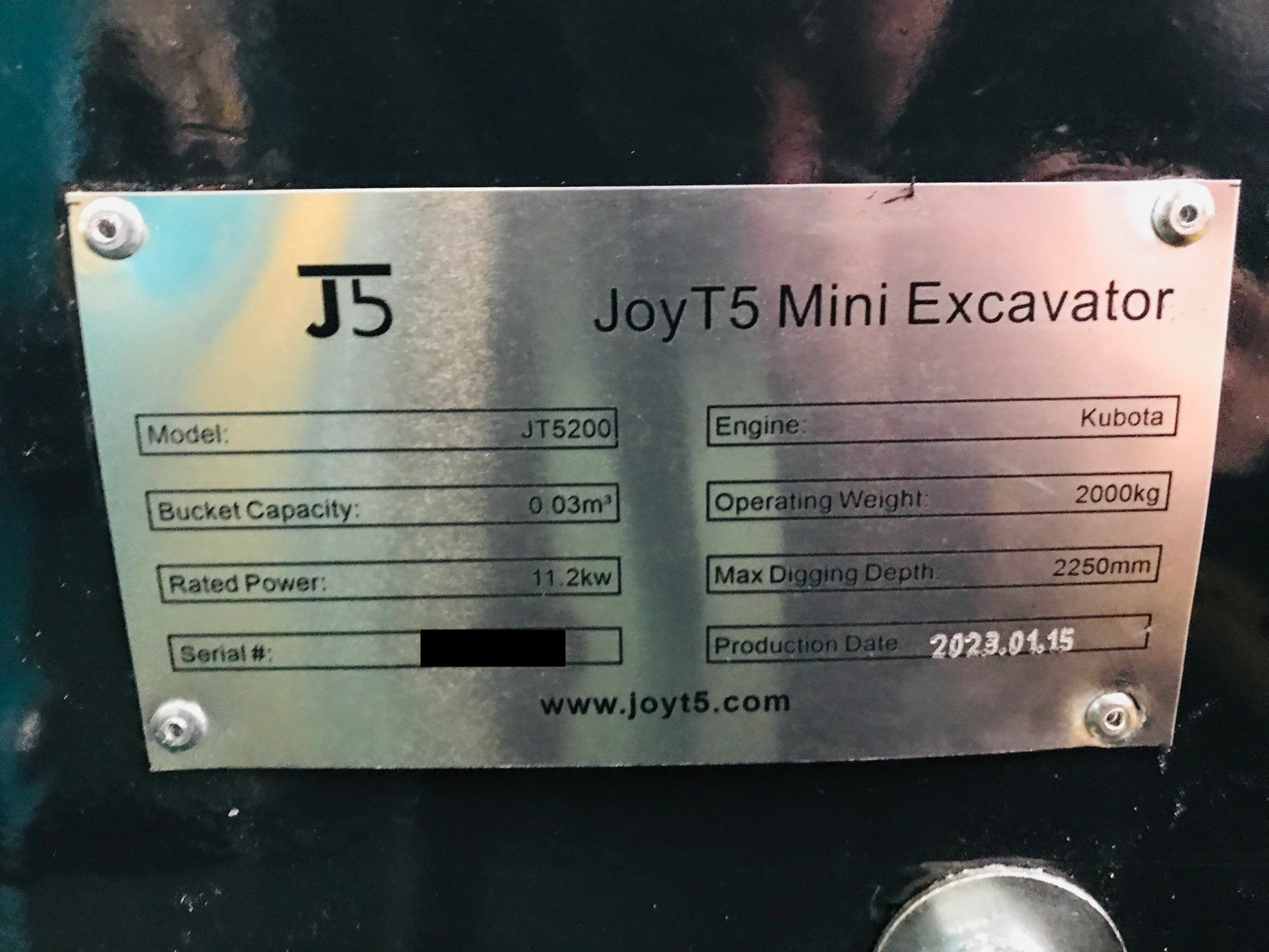 Specification plate of JoyT5 JT5200 Mini Excavator showing details: Kubota engine, 2000kg operating weight, 0.03m³ bucket capacity, 11.2kw rated power, and 2250mm max digging depth.