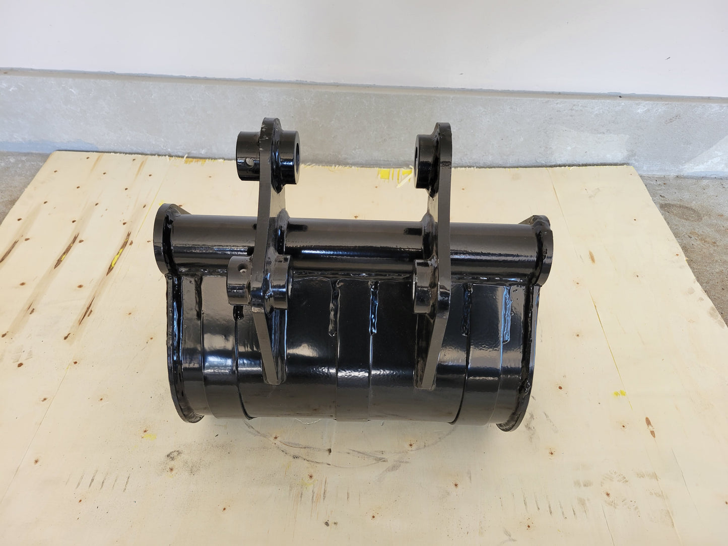 Mini excavator cleanup bucket for Canada showing top view with mounting pins and durable heavy duty bucket design used for landscaping and construction cleanup work.

