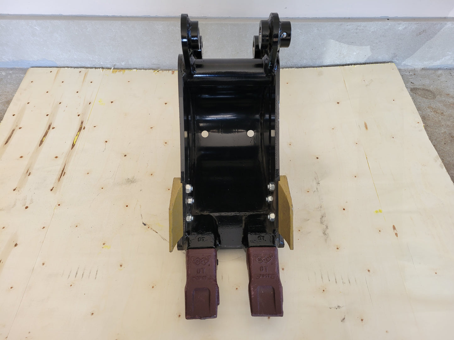 Mini excavator trenching bucket front view showing reinforced steel sides and sharp digging teeth for drainage and construction work in Canada